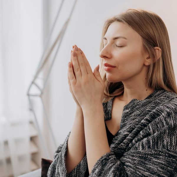 Woman meditating peacefully in a bright, modern room.